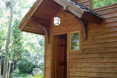 Diseño de fachada de casa rústica grande de una planta con revestimiento de madera, tejado a dos aguas y tejado de teja de madera