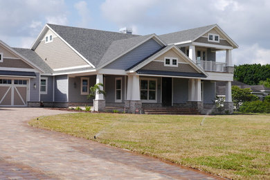 Modelo de fachada de casa multicolor de estilo americano grande de dos plantas con revestimiento de madera y tejado de teja de madera
