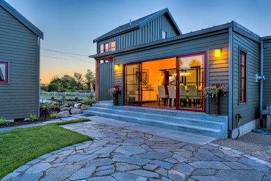 Mid-sized farmhouse gray two-story wood exterior home photo in Seattle with a metal roof