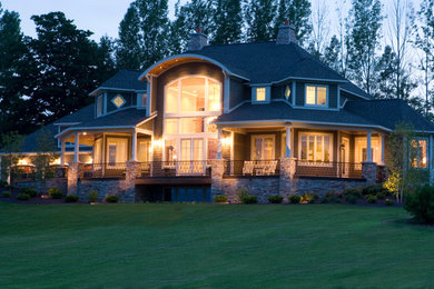 Diseño de fachada de casa gris de estilo americano extra grande de tres plantas con revestimiento de vinilo, tejado a cuatro aguas y tejado de teja de madera