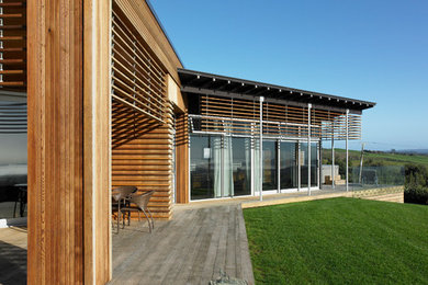 Cette image montre une grande façade de maison marron design en bois.