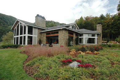 This is an example of a large and gey contemporary two floor house exterior in Boston with mixed cladding and a pitched roof.