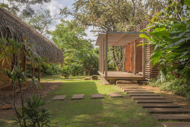 Ispirazione per la facciata di una casa tropicale con rivestimento in legno e tetto piano