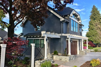 Large and gey traditional two floor detached house in Seattle with a hip roof and a shingle roof.