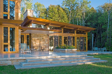 Ejemplo de fachada de casa contemporánea grande de dos plantas con revestimiento de vidrio y tejado de un solo tendido