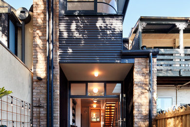 Kleines, Zweistöckiges Modernes Einfamilienhaus mit Backsteinfassade, roter Fassadenfarbe und Flachdach in Sydney