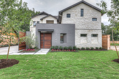 Large contemporary gray two-story stone gable roof idea in Houston