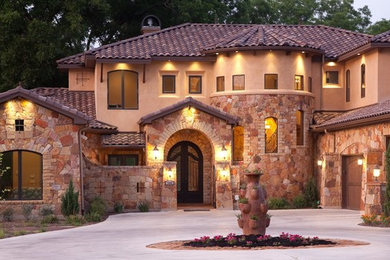 Huge mediterranean brown two-story stone exterior home idea in Austin