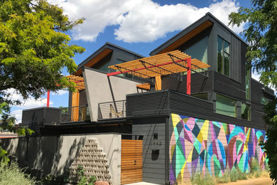 Inspiration for a mid-sized industrial gray three-story mixed siding duplex exterior remodel in Denver with a shed roof and a metal roof