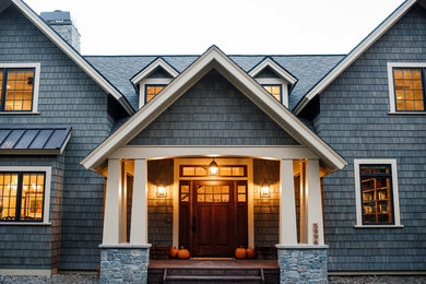 На фото: большой, двухэтажный, деревянный, серый частный загородный дом в стиле рустика с двускатной крышей и крышей из гибкой черепицы с