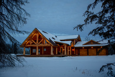 Mid-sized mountain style brown two-story wood exterior home photo in Vancouver with a metal roof