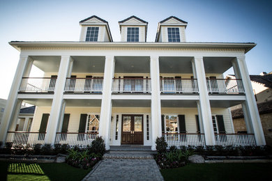 Example of a large classic yellow three-story wood house exterior design in Houston