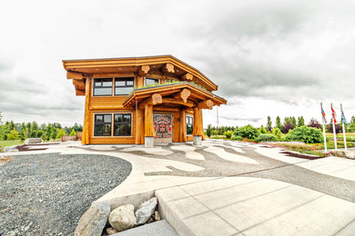 This is an example of a medium sized and brown rustic two floor house exterior in Vancouver with wood cladding, a pitched roof and a green roof.