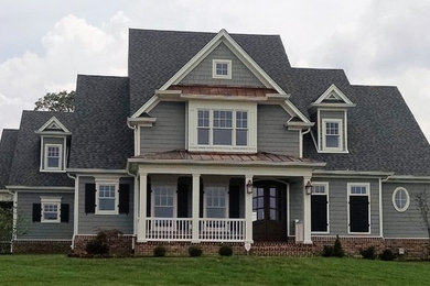 Large transitional gray two-story concrete fiberboard exterior home photo in Other with a shingle roof
