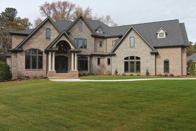 Ispirazione per la facciata di una casa ampia marrone classica a due piani con rivestimento in pietra e abbinamento di colori