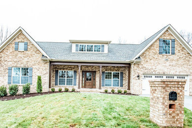 Example of a brown brick exterior home design in Other with a shingle roof