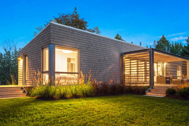Minimalist gray wood exterior home photo in Other with a metal roof