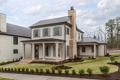 Mid-sized beige two-story concrete fiberboard house exterior idea in Other with a metal roof