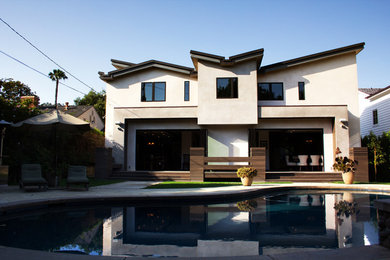 This is an example of a large and beige modern two floor render house exterior in Los Angeles.