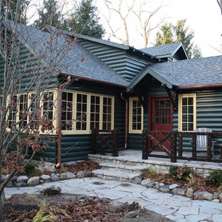 Immagine della facciata di una casa verde rustica con rivestimento in legno