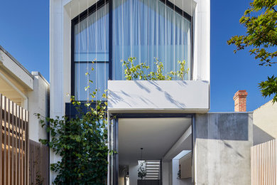 White contemporary two floor glass detached house in Melbourne with a pitched roof and a metal roof.