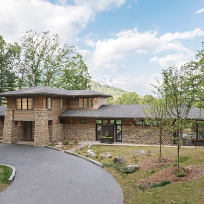 Large modern brown three-story wood house exterior idea in Other with a hip roof and a metal roof