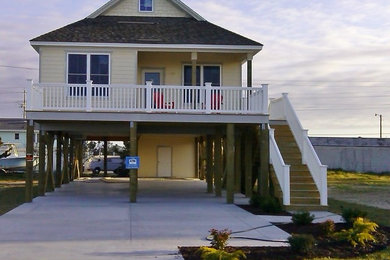 Example of a mid-sized beach style yellow one-story concrete fiberboard exterior home design in Other