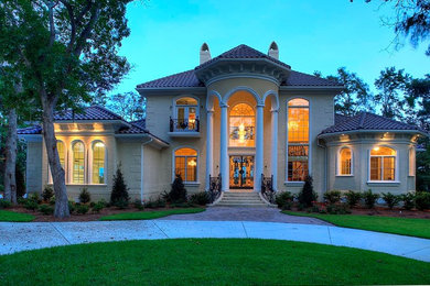 Large elegant beige two-story brick exterior home photo in Charleston with a hip roof