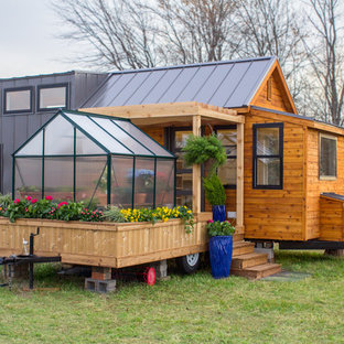Modelo de fachada marrón, de estilo de casa de campo, de una planta, con revestimientos combinados, tejado a dos aguas y tejado de metal