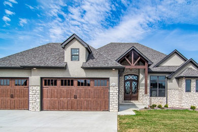 Example of a classic beige one-story mixed siding house exterior design in Other with a hip roof and a shingle roof