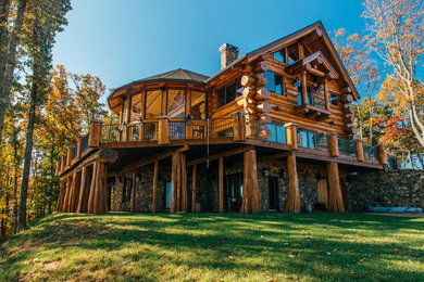 Ejemplo de fachada de casa beige rural de tamaño medio de tres plantas con tejado a dos aguas, tejado de teja de madera y revestimiento de madera