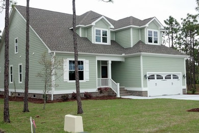 Inspiration for a large coastal green two-story wood exterior home remodel in Wilmington with a shingle roof