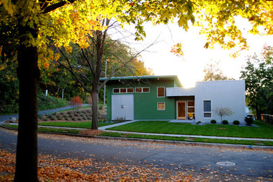 Diseño de fachada verde minimalista de tamaño medio de una planta con revestimiento de metal y tejado plano