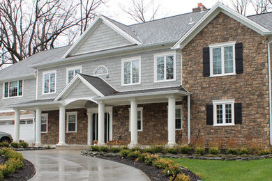 Cette photo montre une grande façade de maison grise chic à un étage avec un revêtement mixte.