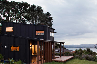 Идея дизайна: двухэтажный, деревянный, черный, маленький дом в современном стиле для на участке и в саду