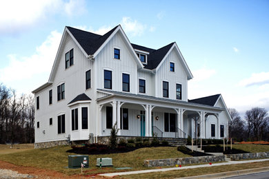 Inspiration for a cottage white board and batten exterior home remodel in Baltimore with a black roof and a shingle roof