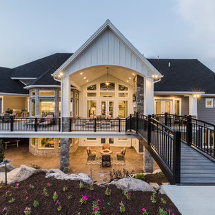 Cette image montre une façade de maison grise craftsman à un étage avec un revêtement en vinyle, un toit à deux pans et un toit en shingle.