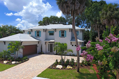 Inspiration for a large transitional white two-story stucco exterior home remodel in Tampa with a hip roof