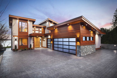 Large trendy two-story mixed siding house exterior photo in Vancouver with a shed roof