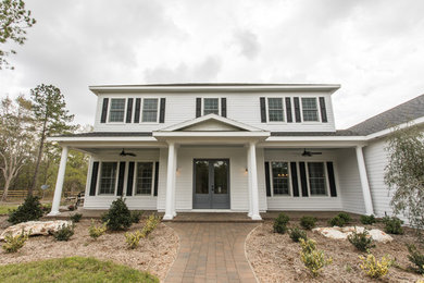 Modelo de fachada de casa blanca tradicional grande de dos plantas con revestimiento de aglomerado de cemento, tejado a dos aguas y tejado de teja de madera