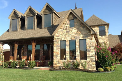 Inspiration for a mid-sized rustic beige two-story stone exterior home remodel in Other