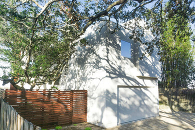 Ejemplo de fachada de casa blanca actual de tamaño medio de tres plantas con revestimiento de estuco, tejado a dos aguas y tejado de varios materiales