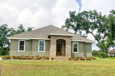 Imagen de fachada de casa clásica de dos plantas con revestimiento de aglomerado de cemento y tejado de teja de madera
