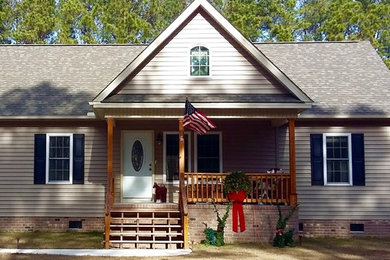 Mittelgroßes, Zweistöckiges Country Einfamilienhaus mit Faserzement-Fassade, grauer Fassadenfarbe, Satteldach und Schindeldach in Sonstige