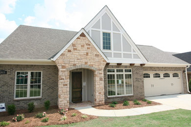 Example of a mid-sized classic beige two-story brick exterior home design in Other with a shingle roof