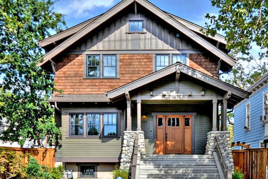 Foto della facciata di una casa verde american style a due piani con rivestimento in legno e tetto a capanna