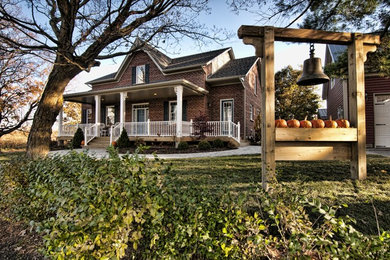 Inspiration for a large timeless red two-story brick exterior home remodel in Toronto