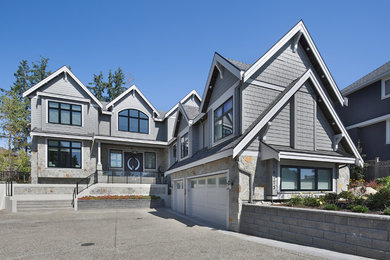 Example of a large transitional gray two-story wood exterior home design in Vancouver with a shingle roof