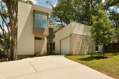 Example of a mid-sized minimalist white two-story stucco exterior home design in Austin