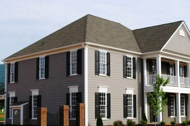 Diseño de fachada gris grande de tres plantas con revestimiento de vinilo